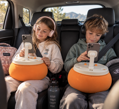 2 enfants utilisant le coussin support téléphone MyMocky orange dans la voiture